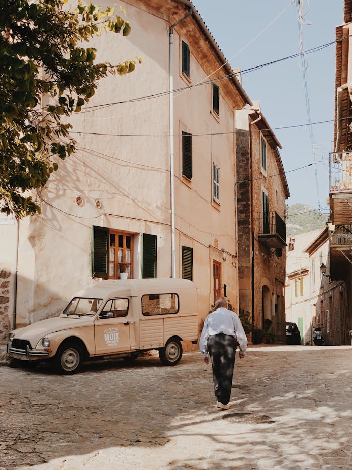 services-03 Charming Valldemossa village scene with vintage car and rustic architecture.